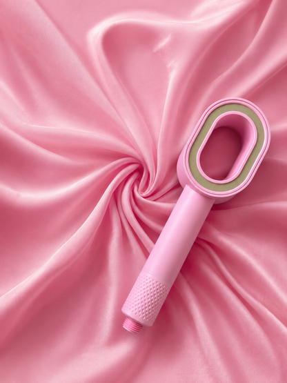 Image du pommeau de douche filtrant rose suimy, posé sur un décor rose et équipé du filtre ACF au charbon actif anti chlore et anti calcaire a effet spa
