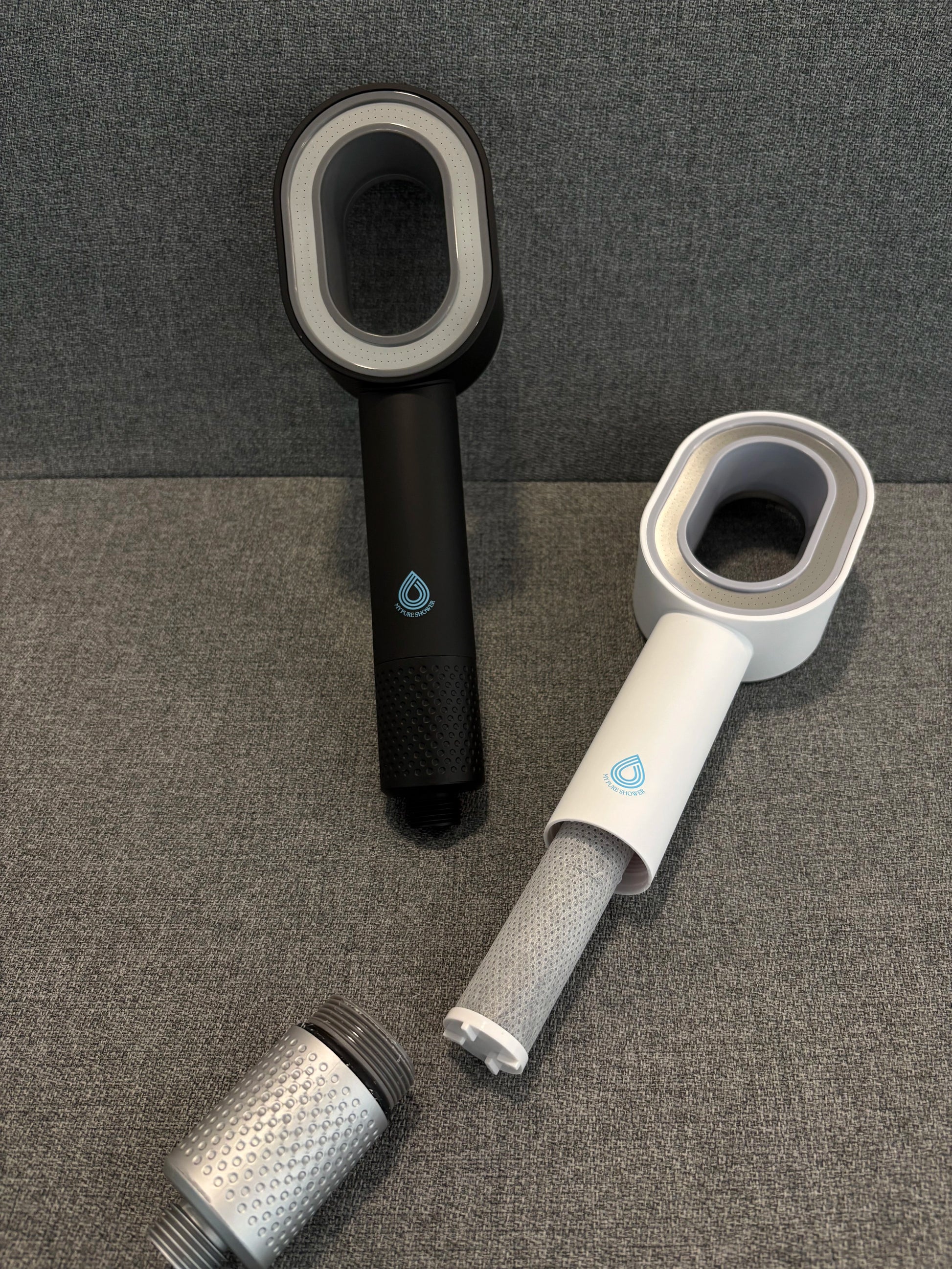 Image du pack domino avec deux pommeaux de douches filtrants, un noir et l’autre blanc ; de plus, un filtre ACF gris  adaptable à l’ensemble des flexibles de douche standards.